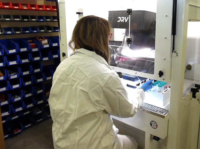 Lab technicial preparing sample using DRV in cabinet